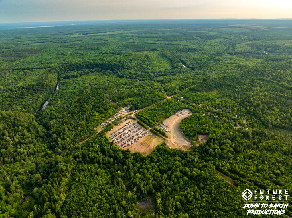 Aerial view of the parking field at Future Forest, cleared in the forest with rows of parked vehicles